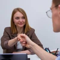 Business professionals engaging in a handshake during a meeting in an office.